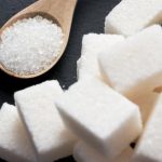 sacharidy bílí cukr na černém pozadí