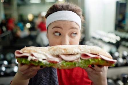 fitness tucna zena drzi sendvic